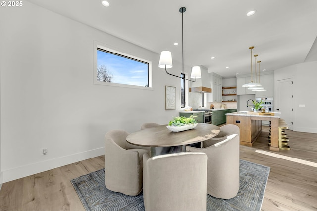 dining area featuring sink and light wood-type flooring