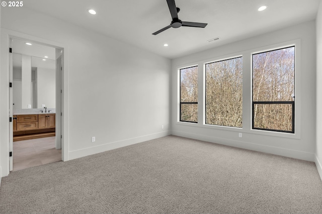 unfurnished bedroom with light carpet, baseboards, a sink, and recessed lighting