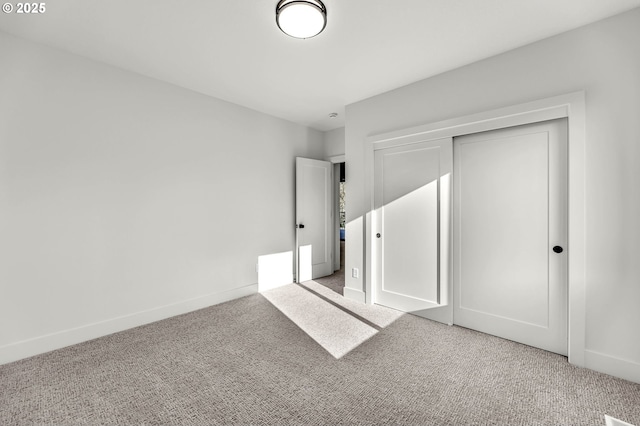 unfurnished bedroom featuring baseboards, a closet, and light colored carpet