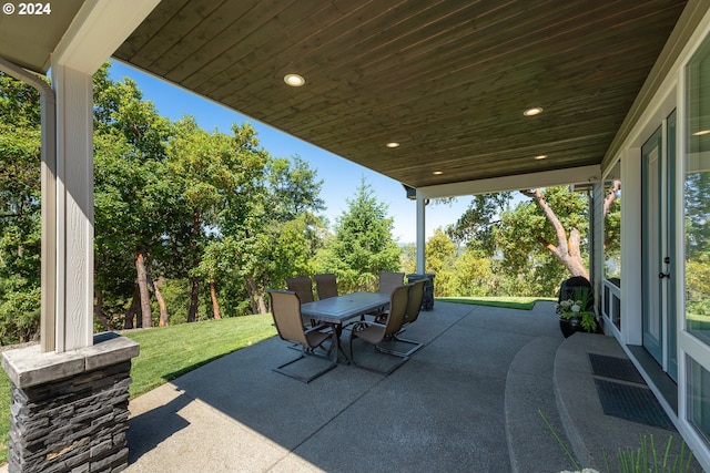 view of patio / terrace with outdoor dining area and view of scattered trees