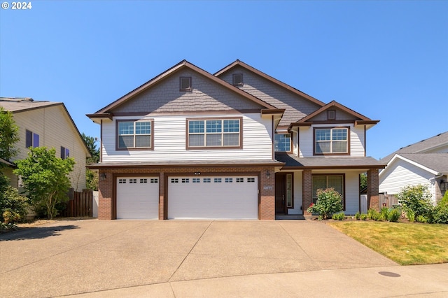 craftsman house featuring a garage and a front yard