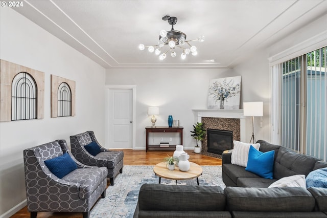 living room with an inviting chandelier, a fireplace, and light hardwood / wood-style flooring