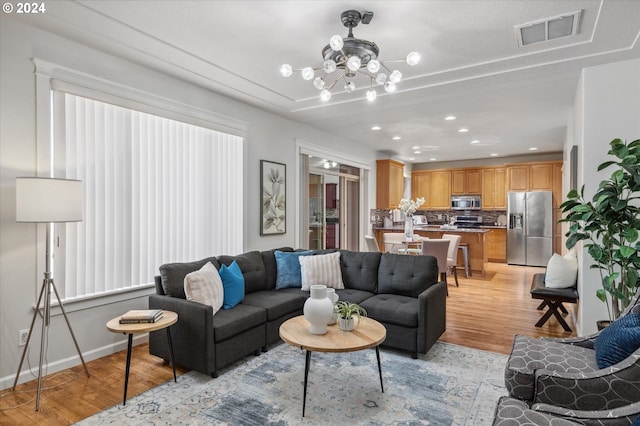 living room featuring light hardwood / wood-style flooring and a notable chandelier