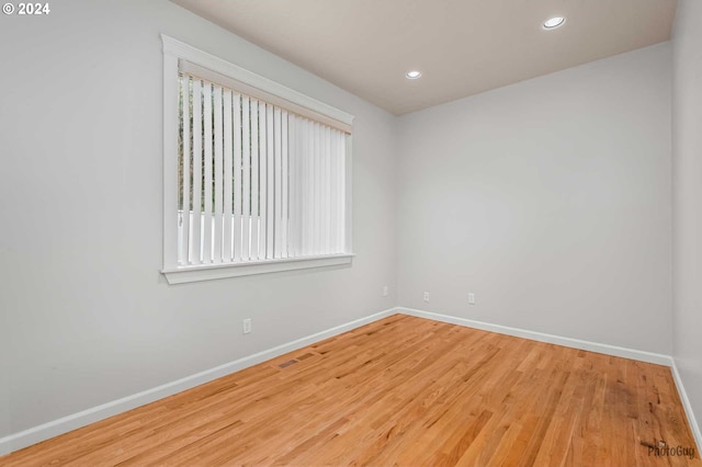 unfurnished room with hardwood / wood-style flooring