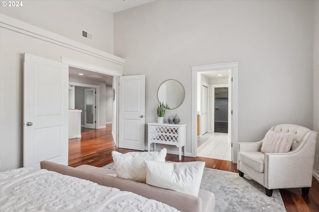 bedroom featuring hardwood / wood-style flooring and a high ceiling