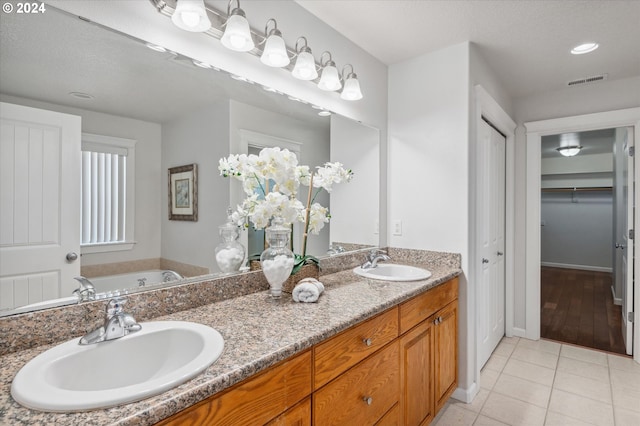 bathroom with vanity, a tub to relax in, and tile patterned floors