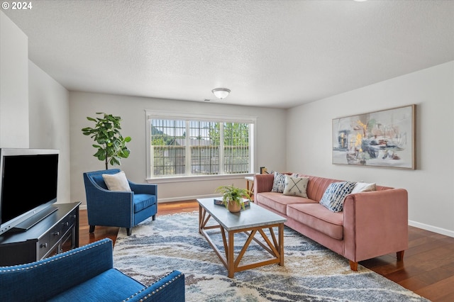 living room with dark wood-type flooring and a textured ceiling