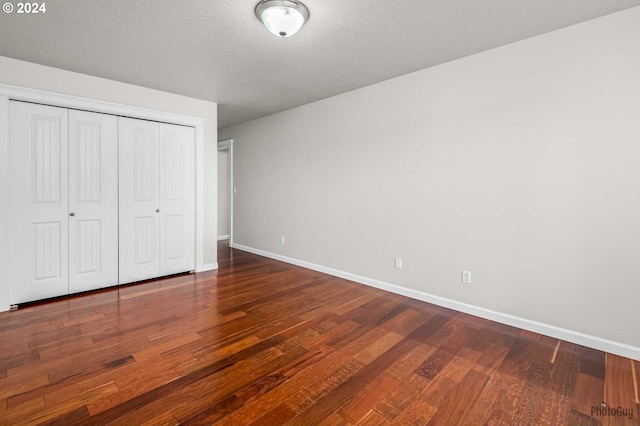 unfurnished bedroom with hardwood / wood-style flooring, a textured ceiling, and a closet