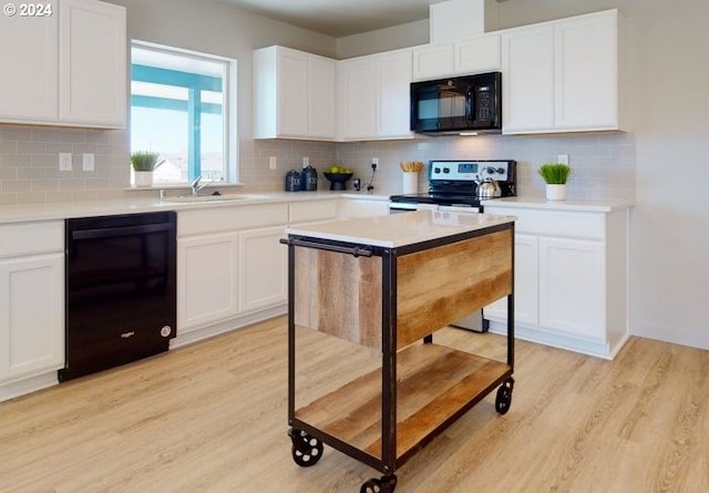 kitchen featuring electric stove, sink, light wood-type flooring, white cabinets, and tasteful backsplash