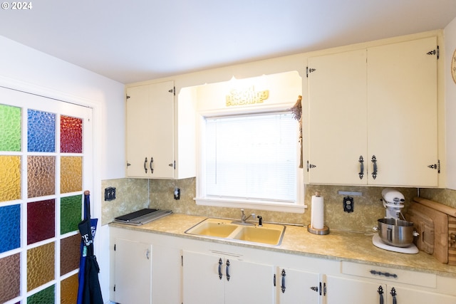 kitchen featuring tasteful backsplash, sink, and white cabinets