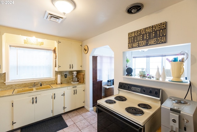 kitchen featuring electric stove, white cabinetry, sink, and decorative backsplash