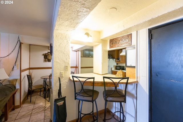 kitchen featuring a breakfast bar, tile patterned floors, and kitchen peninsula