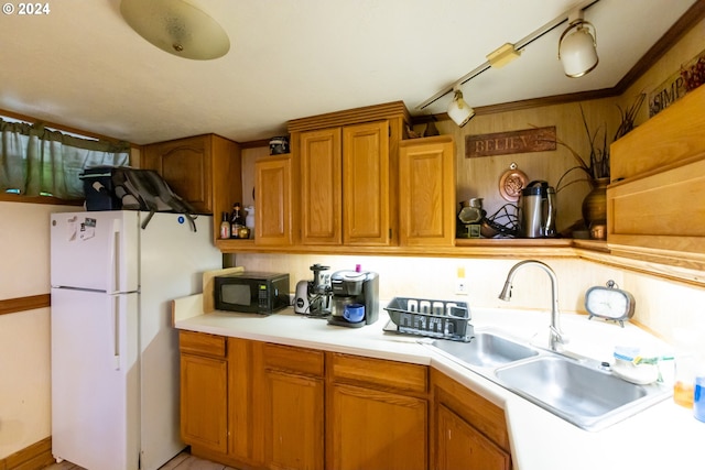 kitchen with white refrigerator, sink, and track lighting