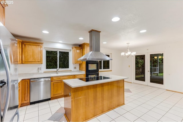 kitchen with hanging light fixtures, island range hood, sink, a kitchen island, and stainless steel appliances