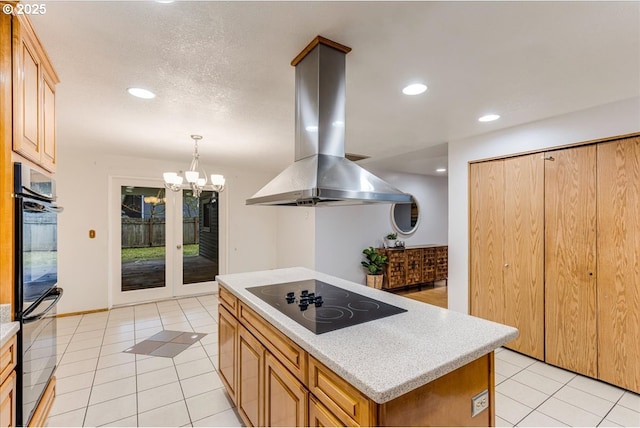 kitchen with black electric stovetop, hanging light fixtures, light tile patterned floors, island range hood, and a kitchen island