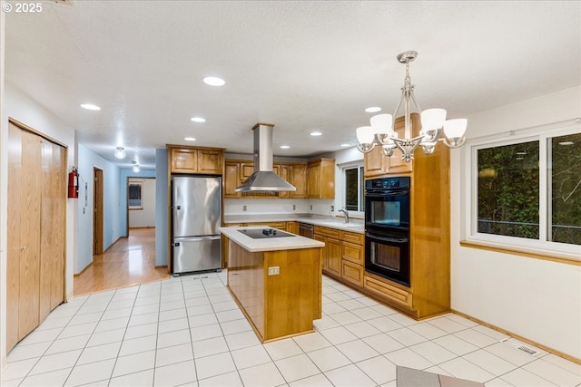 kitchen with black appliances, island exhaust hood, hanging light fixtures, sink, and a kitchen island