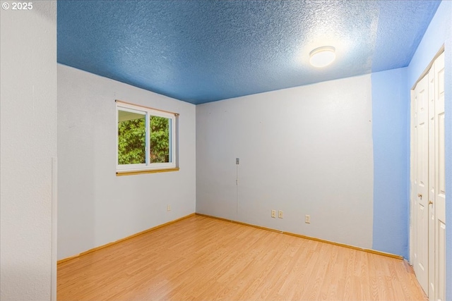 unfurnished bedroom with light hardwood / wood-style floors and a textured ceiling