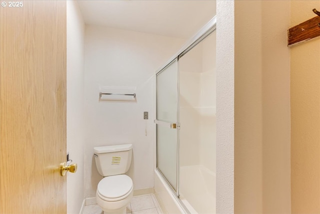 bathroom with tile patterned floors, toilet, and combined bath / shower with glass door