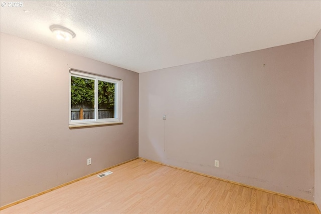 spare room with wood-type flooring and a textured ceiling