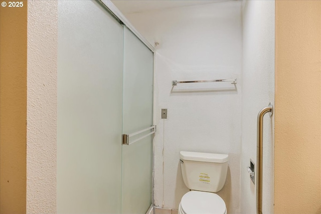 bathroom with toilet and an enclosed shower