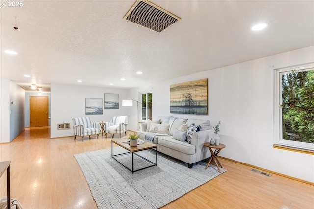 living room featuring hardwood / wood-style flooring, a textured ceiling, and a wealth of natural light