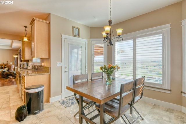 dining area with a wealth of natural light, sink, light hardwood / wood-style flooring, and a notable chandelier