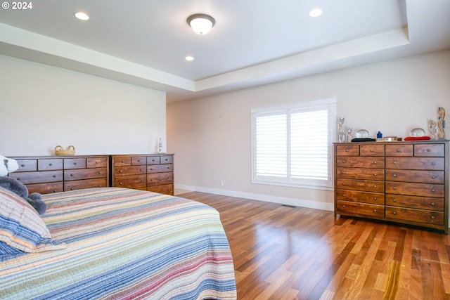 bedroom featuring a raised ceiling and hardwood / wood-style floors