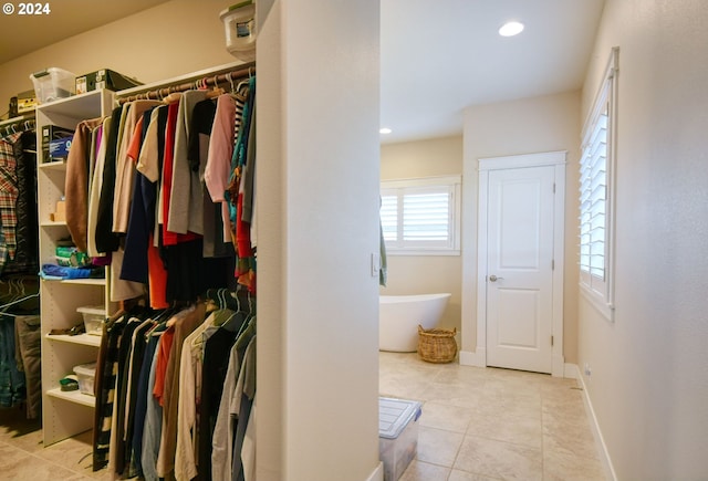 walk in closet with light tile floors