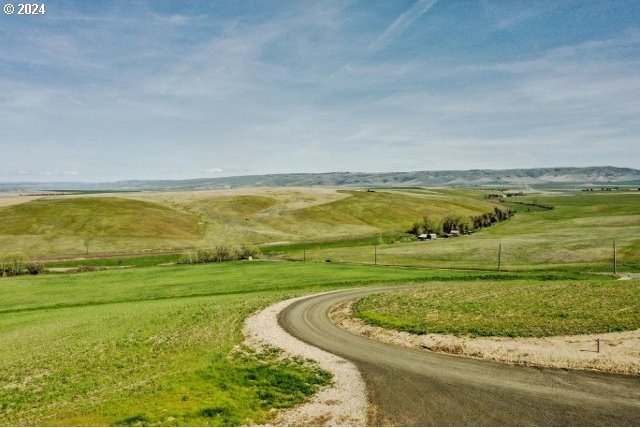 view of home's community with a rural view and a lawn