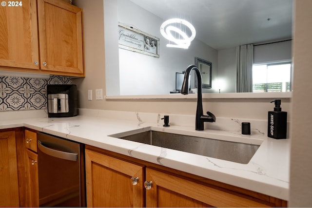 kitchen with sink, decorative backsplash, dishwasher, and light stone countertops