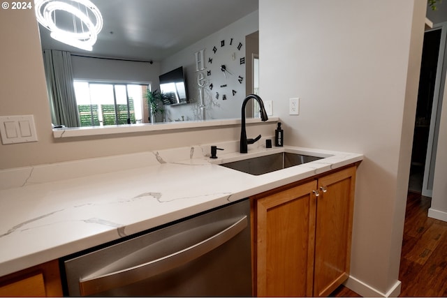 kitchen featuring light stone counters, sink, stainless steel dishwasher, and dark hardwood / wood-style flooring