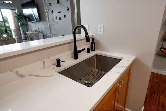 kitchen featuring sink and light stone countertops