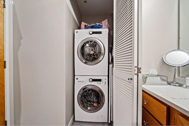 clothes washing area featuring stacked washing maching and dryer