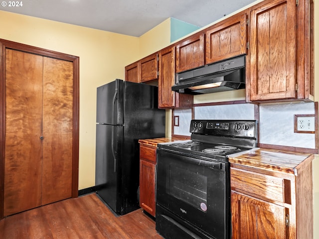 kitchen featuring black appliances and dark hardwood / wood-style flooring