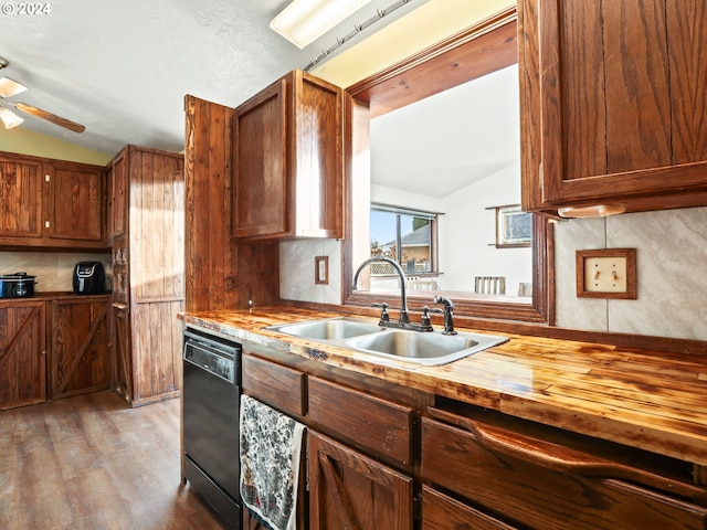 kitchen with lofted ceiling, dishwasher, sink, and tasteful backsplash