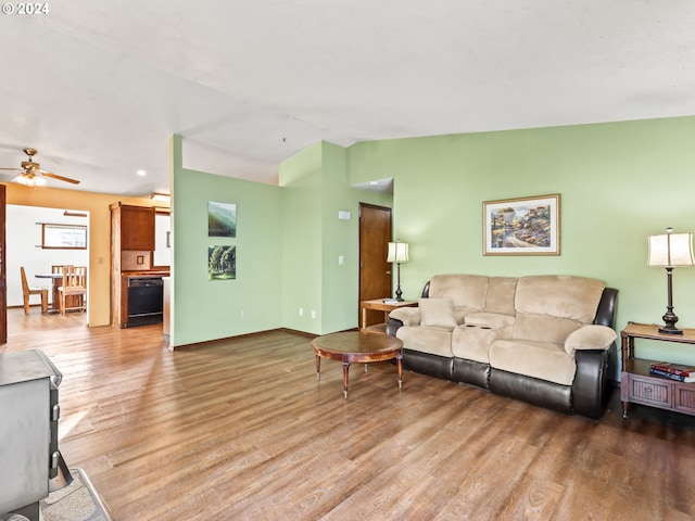 living room with hardwood / wood-style flooring, ceiling fan, and vaulted ceiling