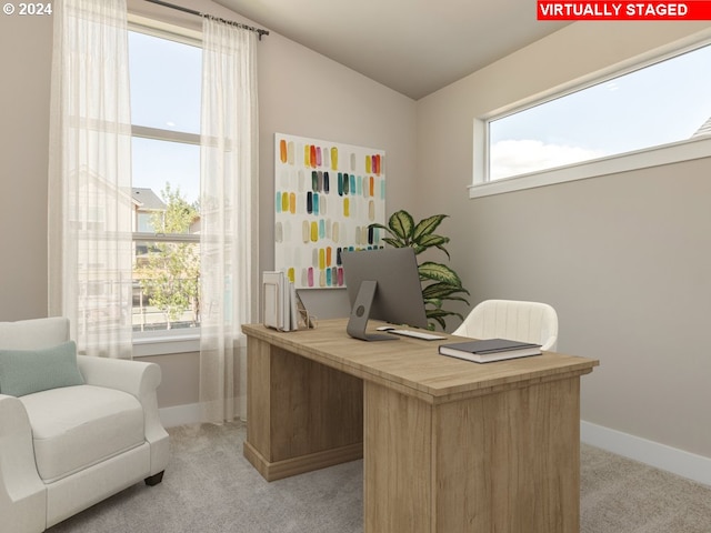 office space featuring plenty of natural light, light colored carpet, and lofted ceiling