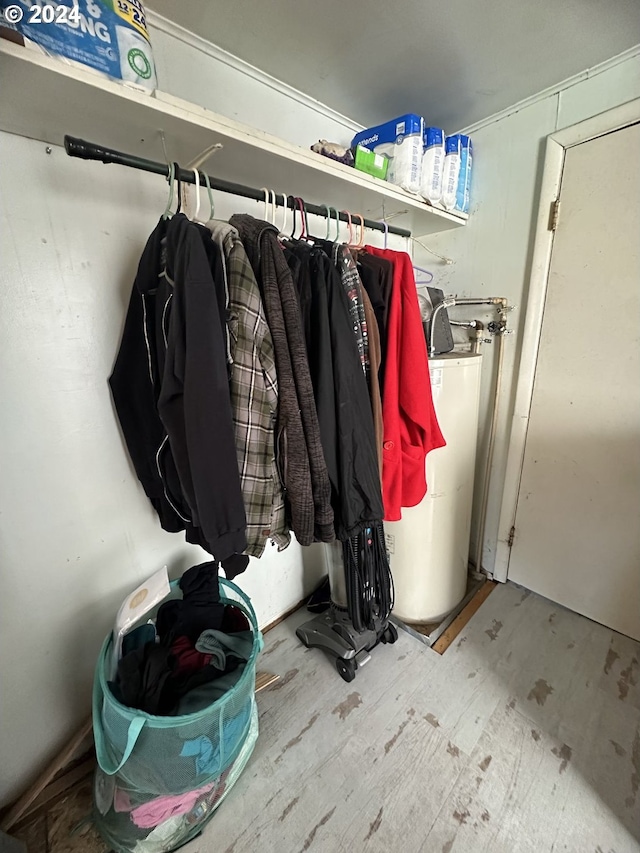 walk in closet with wood-type flooring and gas water heater