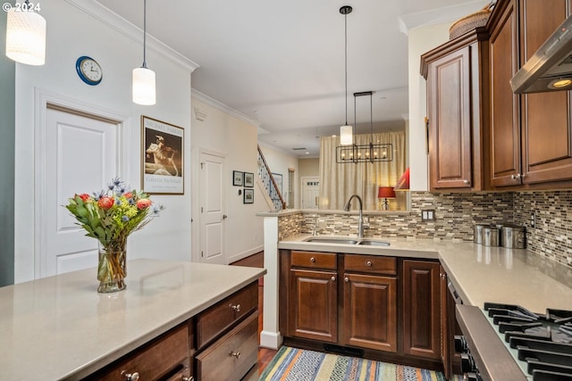 kitchen featuring sink, ornamental molding, backsplash, extractor fan, and pendant lighting