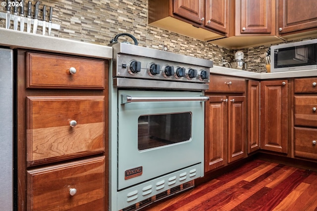 kitchen with stainless steel appliances, dark hardwood / wood-style floors, and decorative backsplash