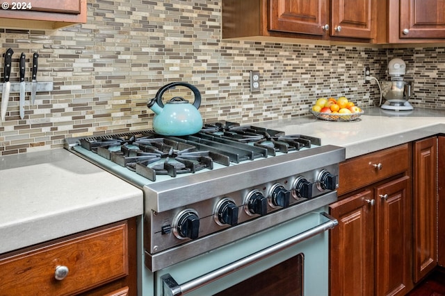 kitchen featuring high end stove and tasteful backsplash