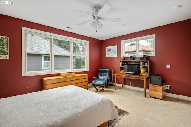 bedroom with ceiling fan, multiple windows, and carpet