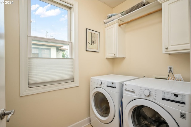 clothes washing area featuring washing machine and clothes dryer and cabinets