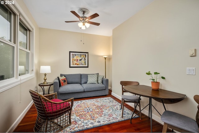 living room with ceiling fan and dark wood-type flooring