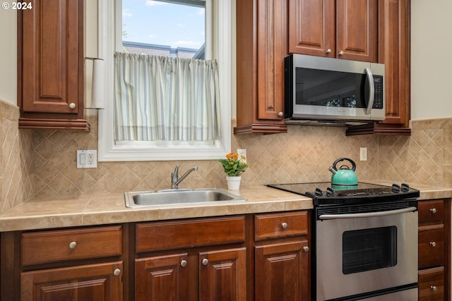 kitchen featuring stainless steel appliances, tasteful backsplash, and sink