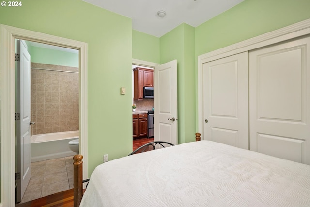 bedroom with ensuite bathroom, a closet, and dark hardwood / wood-style floors