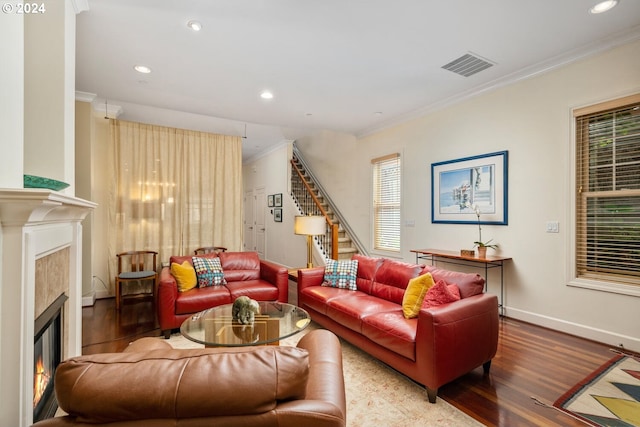 living room with a wealth of natural light, crown molding, and hardwood / wood-style flooring