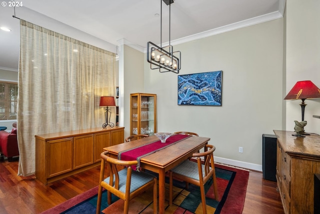 dining space with ornamental molding, dark hardwood / wood-style flooring, and a notable chandelier