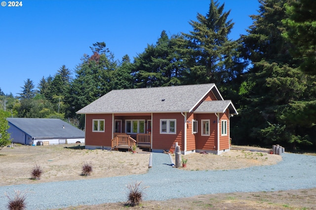 view of front of house featuring a shingled roof and driveway