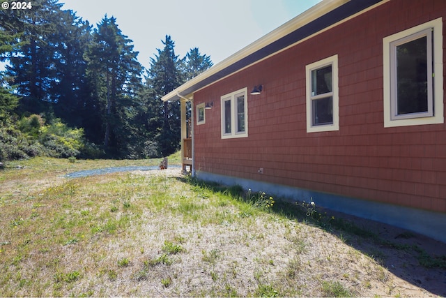 view of side of home with a yard